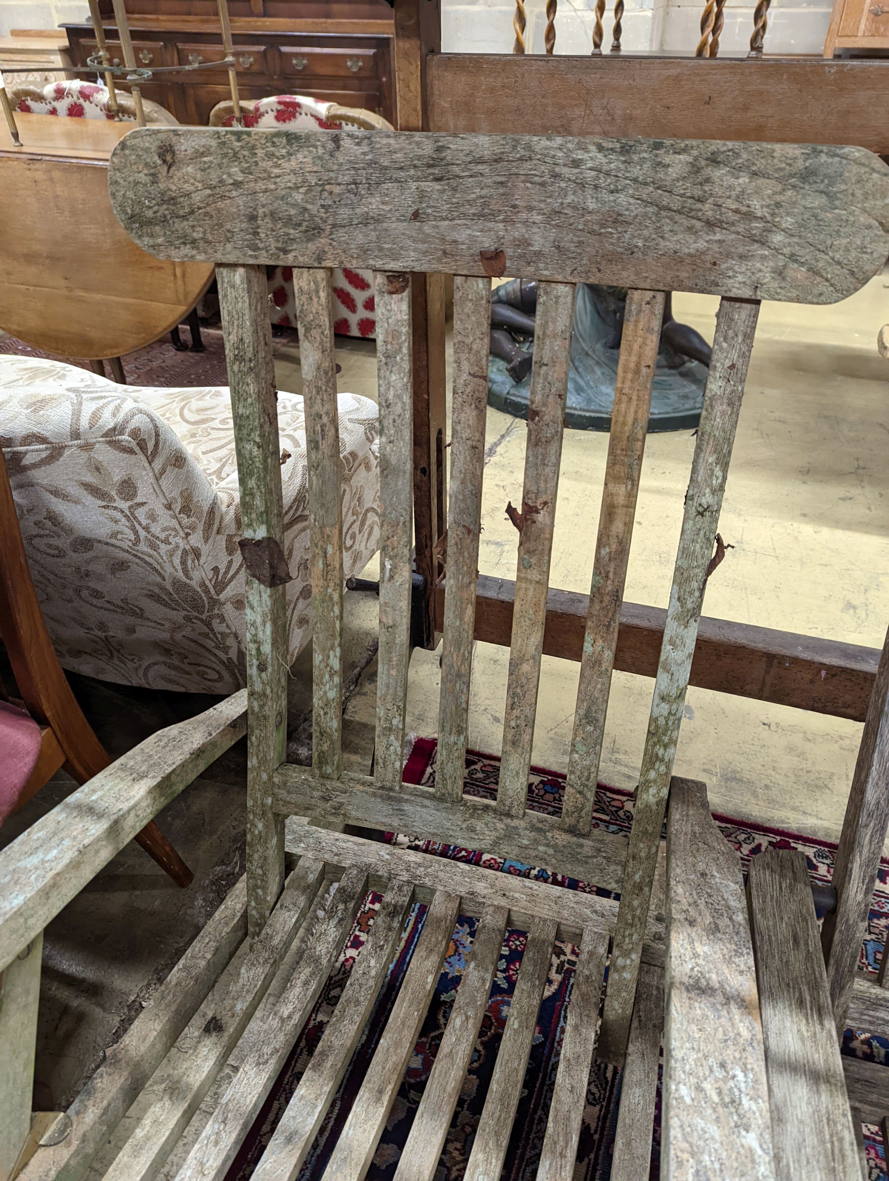 Two weathered teak garden steamer chairs. Heights for both chairs, 102cm and 88cm.
